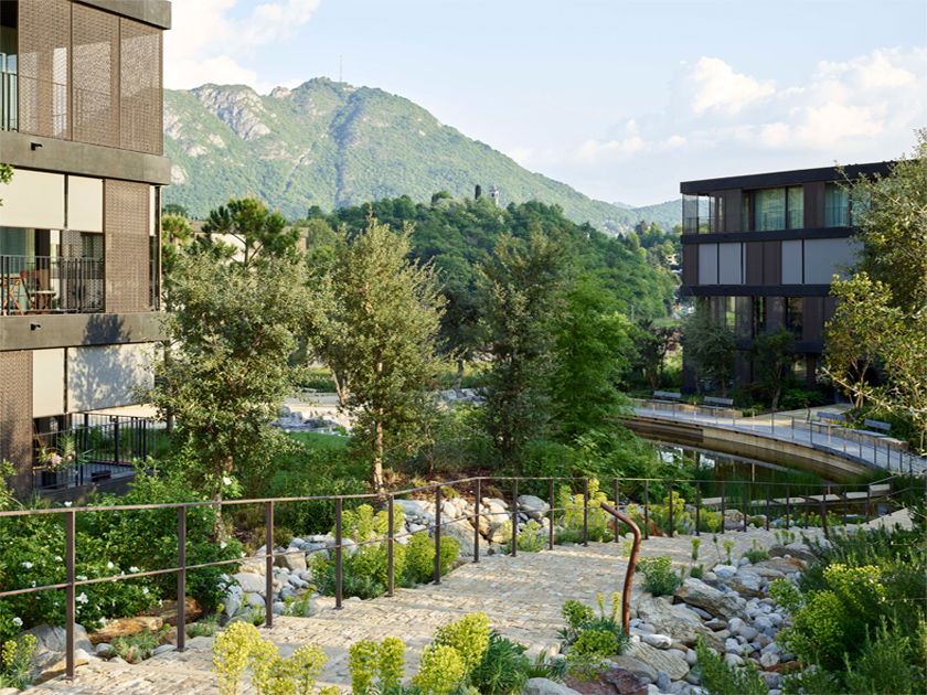 Wohnanlage mit üppiger Vegetation und einem Teich.