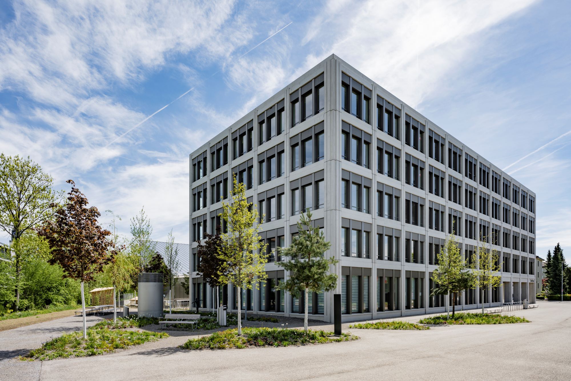 Verwaltungsgebäude mit Baumrigolen auf einem Vorplatz
